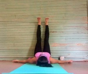 A girl putting leg up the wall for yoga